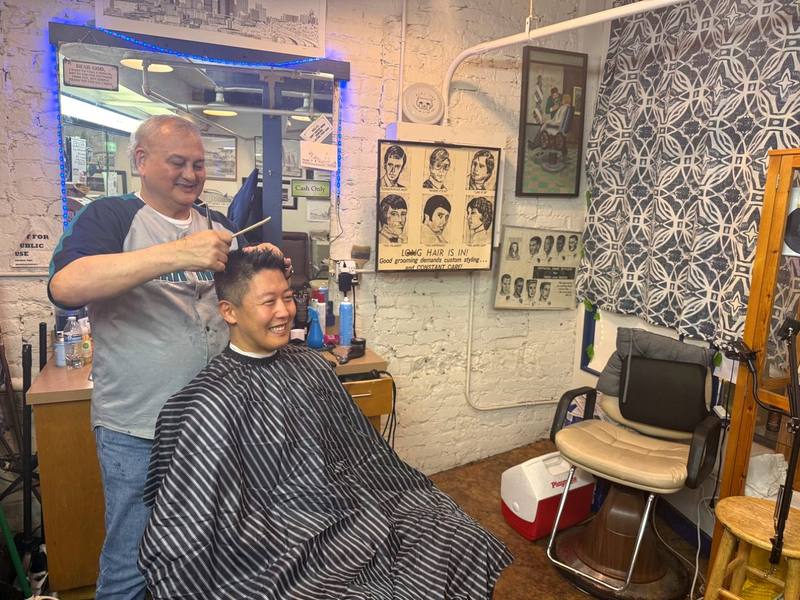Wen the barber cutting a customer's hair at Balcony Barber Shop
