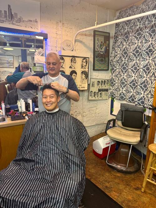 Wen cutting a customer's hair at Balcony Barber Shop