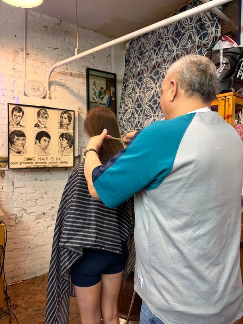 Wen cutting a customer's hair at Balcony Barber Shop